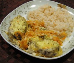 Риба хек с ориз и моркови в чиния на кафява маса
